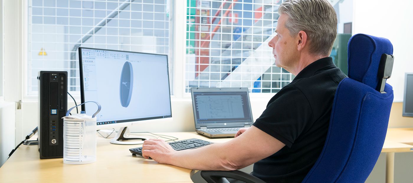Man sitter framför datorn och jobbar med CAD.
